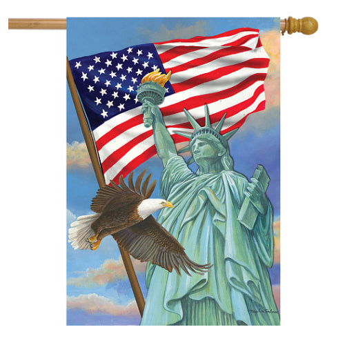 Decorative flag with Statue of Liberty, American flag, and bald eagle against the American flag and a blue sky.