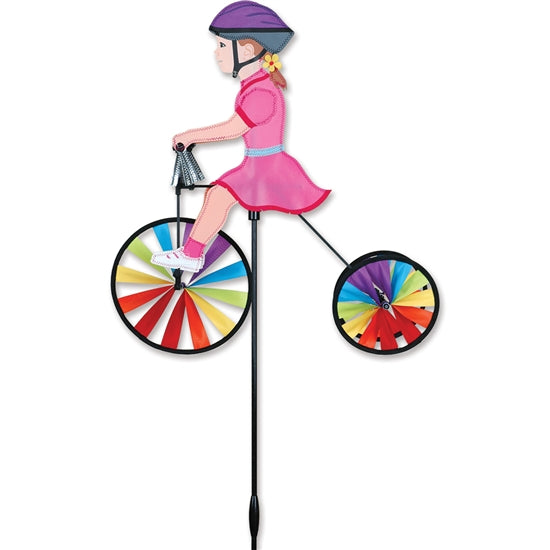 Girl riding a colorful tricycle outdoor wind spinner made with UV-resistant SunTex fabric