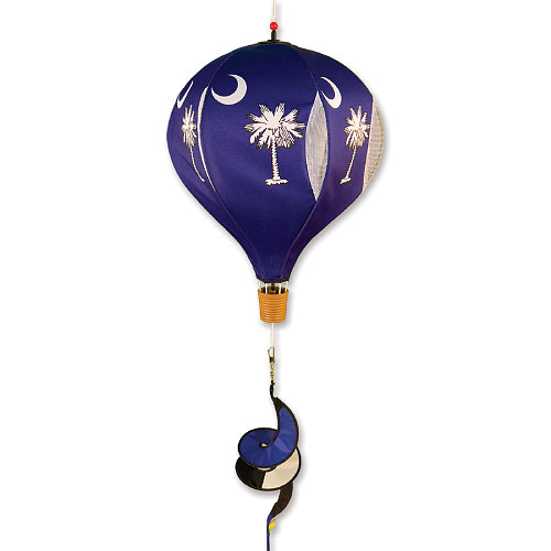 Decorative hot air balloon with palm tree and moon design on a dark blue background