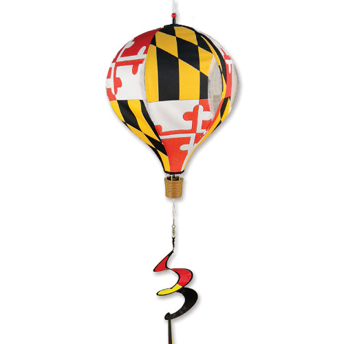 A hot air balloon wind spinner featuring the Maryland state flag pattern with red, white, black, and yellow sections, complete with a brown basket detail and a spiral wind-catching tail.