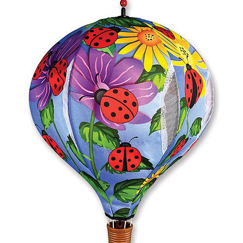 A hot air balloon-shaped garden flag or wall hanging with a colorful print of ladybugs, flowers, and leaves on a light blue background