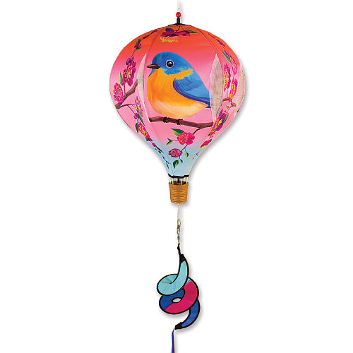 A decorative hot air balloon wind spinner featuring a pink and orange balloon with a bluebird design, a gold-colored basket, and a blue, pink, and orange spiral tail, shown against a plain white background.