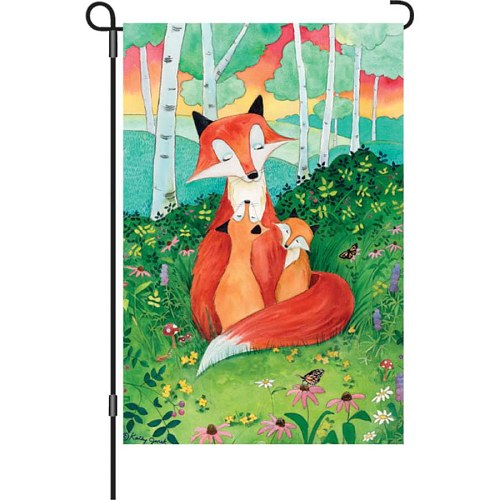 Vertical garden flag displayed on a garden flag stand, featuring a watercolor illustration of a mother red fox cuddling her kit in a flower-filled meadow with birch trees and a colorful sunset sky in the background, by artist Kathy Jurek.