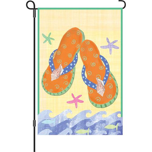 Garden size summer flag displayed on a black metal garden stake, featuring a pair of orange flip flops with blue polka-dot straps, swirl designs, and seashell accents, surrounded by colorful starfish and ocean waves on a yellow background with a green border.