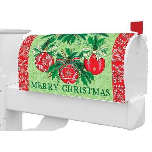 Christmas mailbox cover with red ornaments and green leaves on a patterned background.