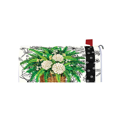 Decorative mailbox cover with a basket full of ferns and white flowers and black and white pattern
