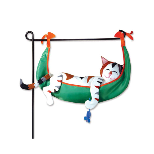 A decorative garden charm featuring a sleeping cat lounging in a green hammock with orange trim, suspended from a black metal garden flag stand. Stand not included.