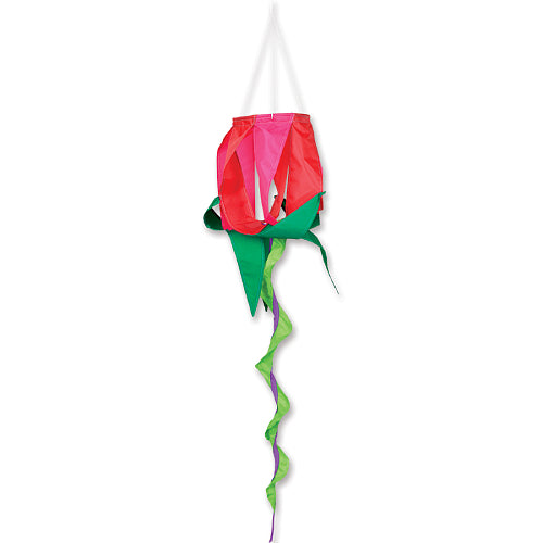 A hanging decorative lantern shaped like a rose, with a bright pink top section, green lower petals, and long curling green and purple ribbon tails, shown against a plain white background.