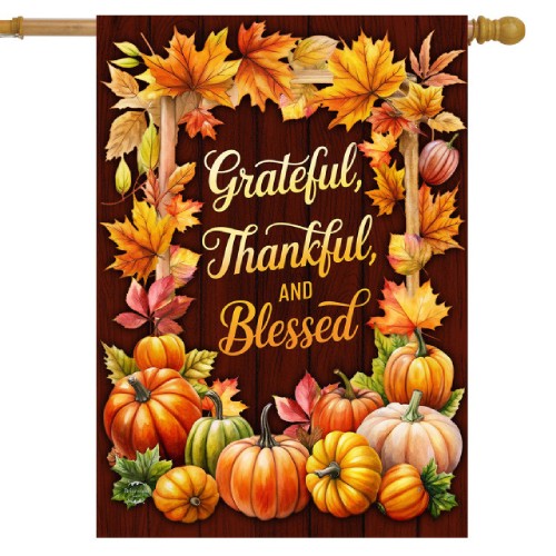 Decorative flag with pumpkins, leaves, and 'Grateful, Thankful, and Blessed' text on a dark wooden background.